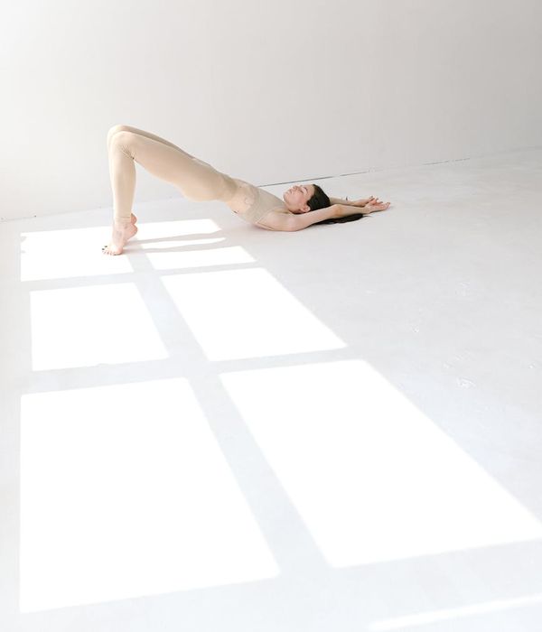 Woman holding a serene yoga pose in a bright, peaceful studio.